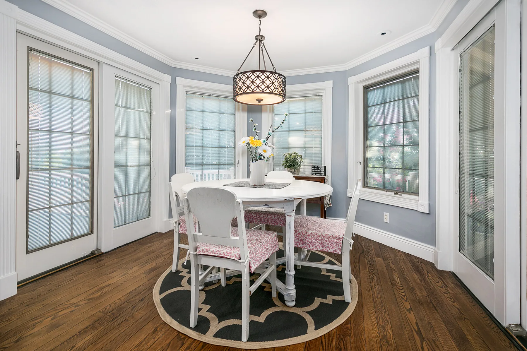 Breakfast nook surrounded by tall windows and glass doors